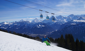 Skifahrer mit Niederhornbahn im Hintergrund und Eiger, Mönch und Jungfrau