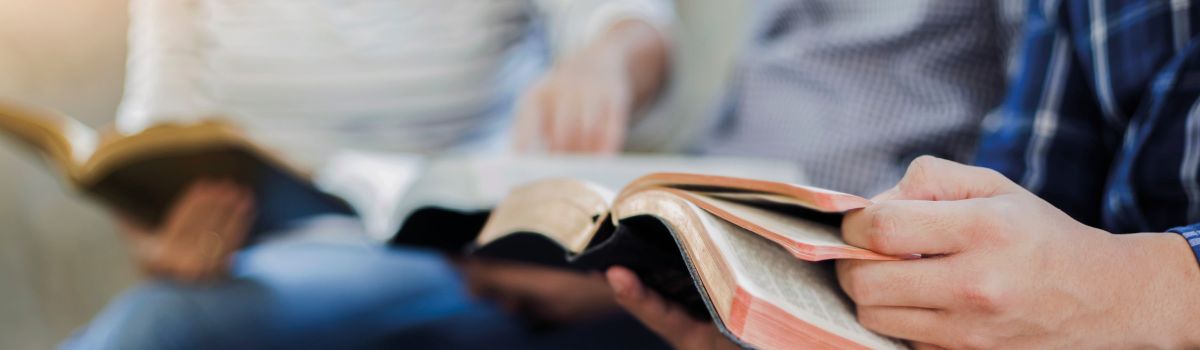 Zwei Menschen mit aufgeschlagener Bibel 